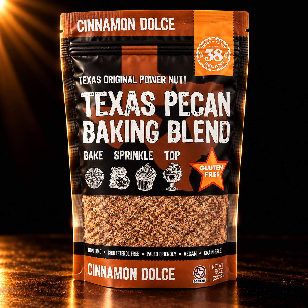 38 Pecans Cinnamon Dolce Texas Pecan Baking Blend in its original black and orange 8 oz pouch, against a dark background with warm golden lighting.